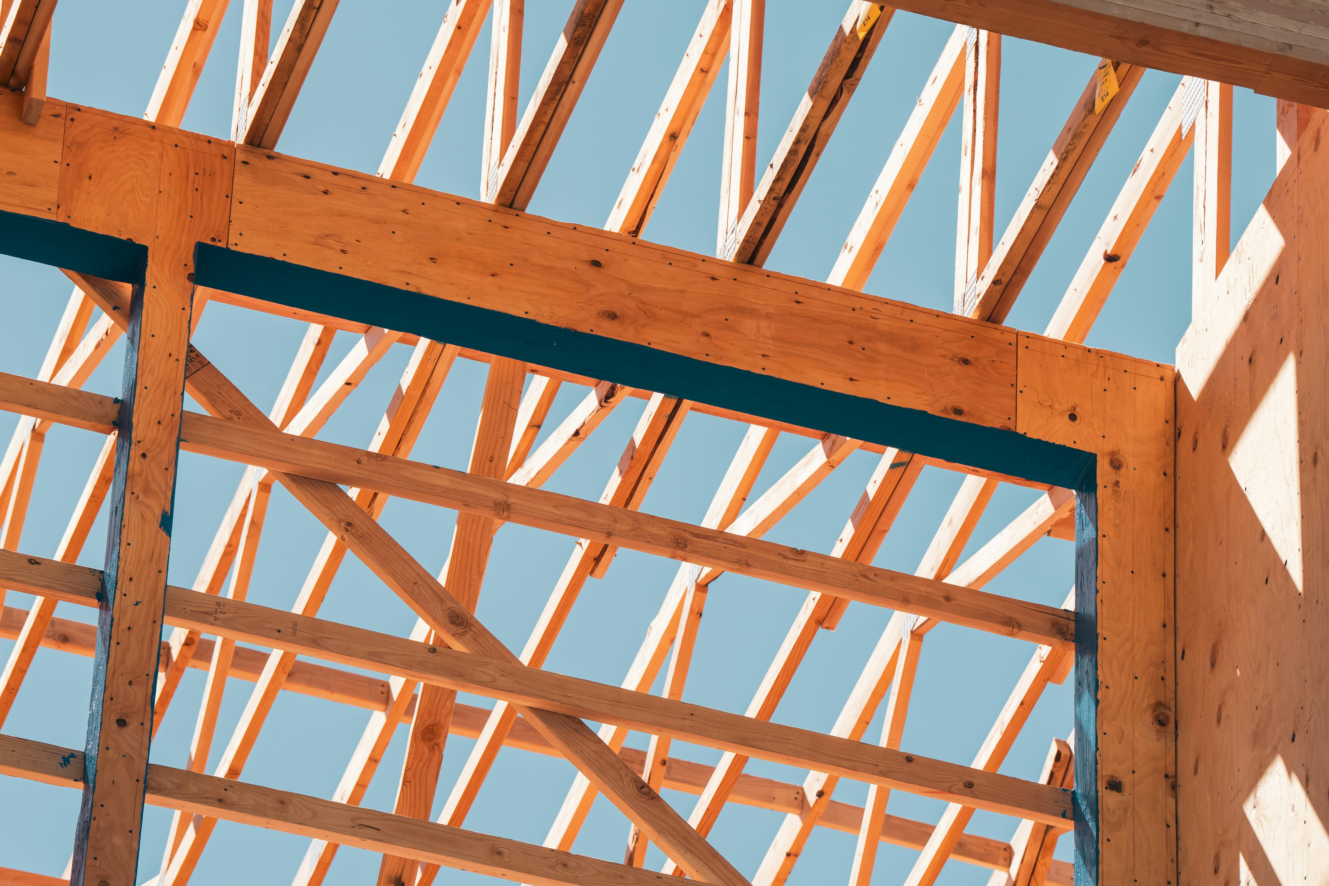 Timber roof structure against a blue sky