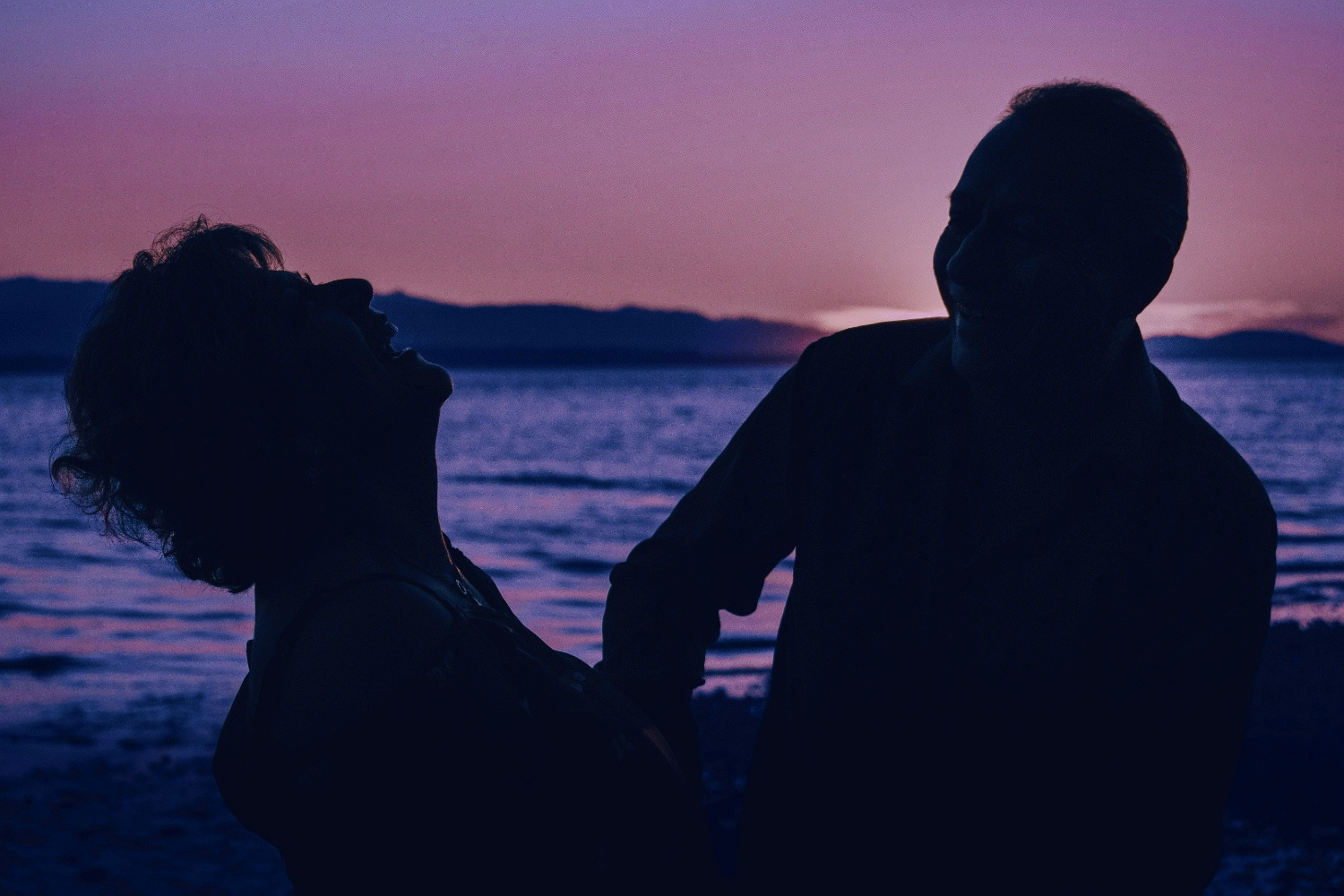 A couple laughing together at sunset