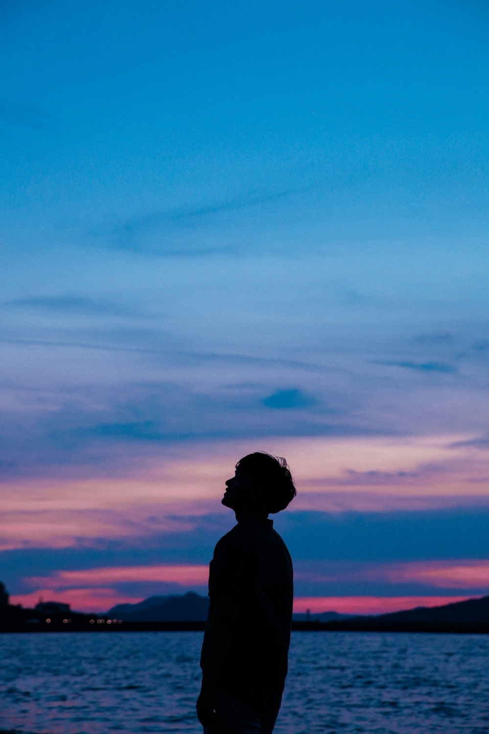 A person walking a path toward the ocean at dusk